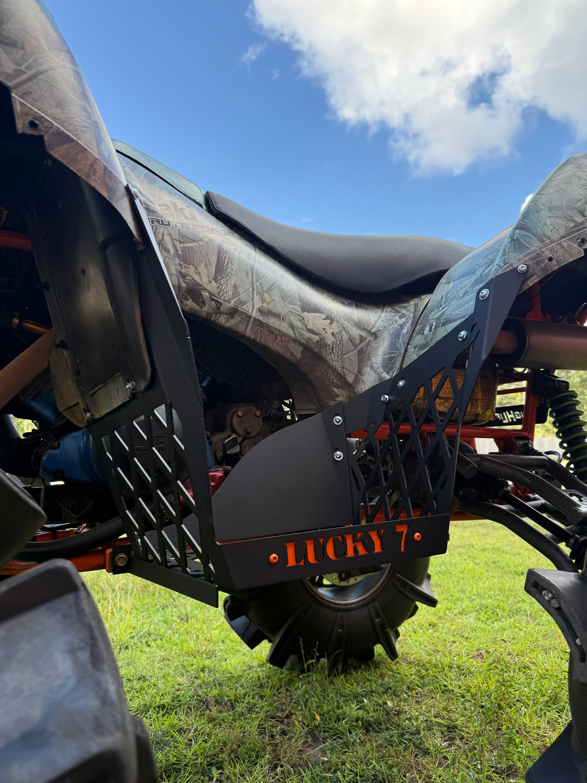 Texture Black Lucky 7 race cut floorboards with orange logo on a Kawasaki Brute Force