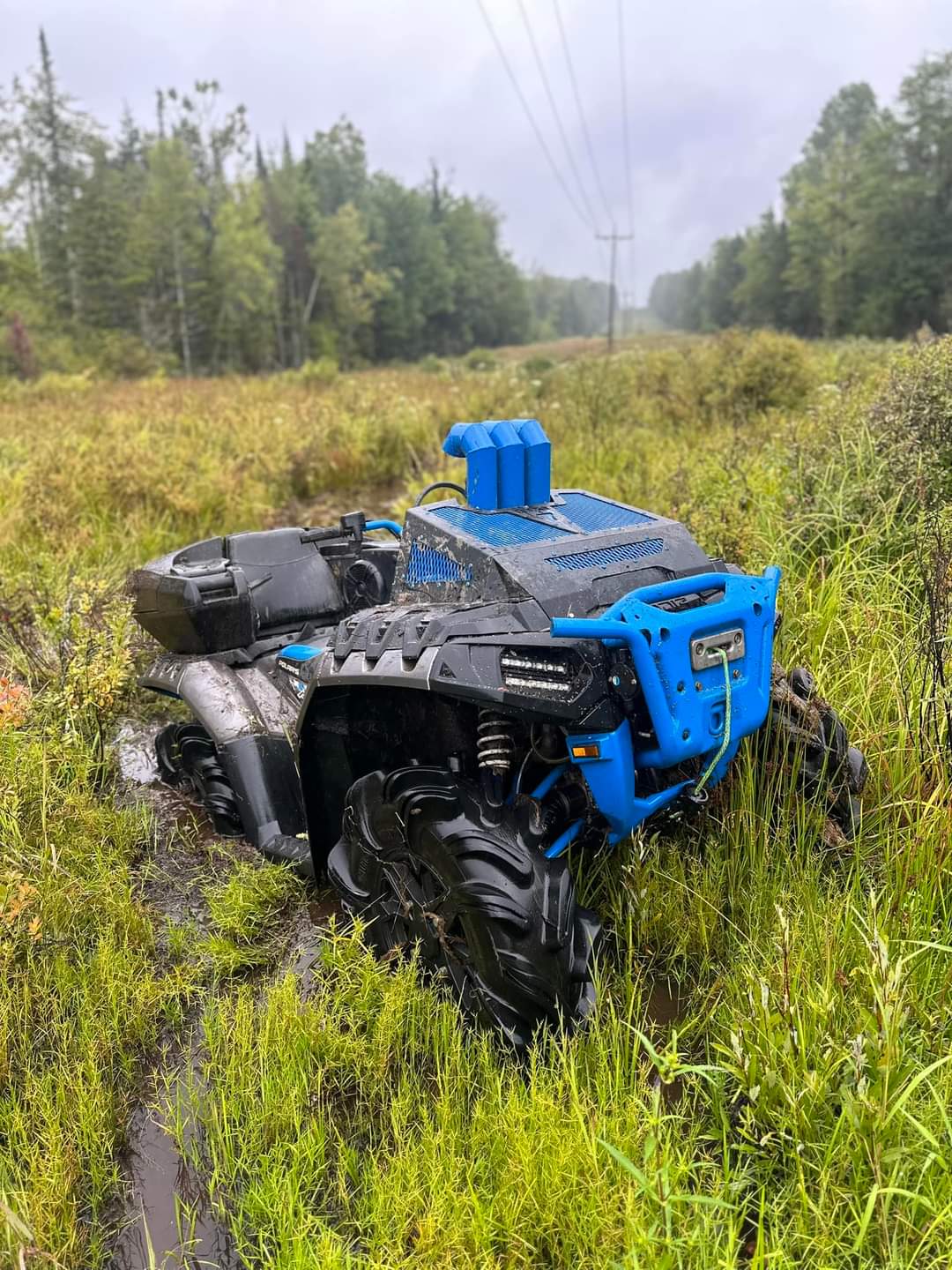 Blue Lucky 7 radiator cover and snorkel risers on a Polaris Sportsman High Lifter