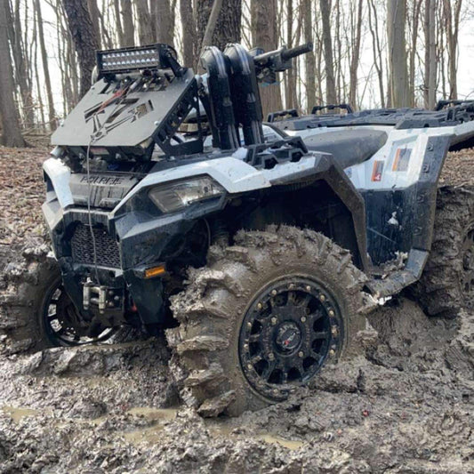 Lucky 7 radiator relocate kit installed on a Polaris Sportsman in the mud