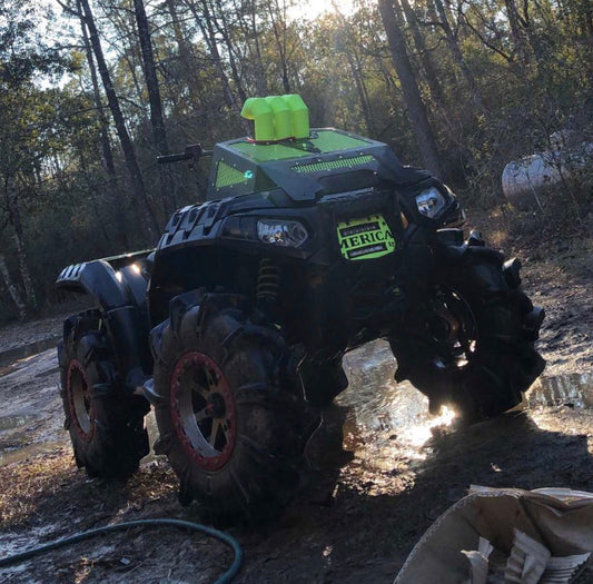 Polaris Sportsman High Lifter in the mud with a Lucky 7 radiator cover