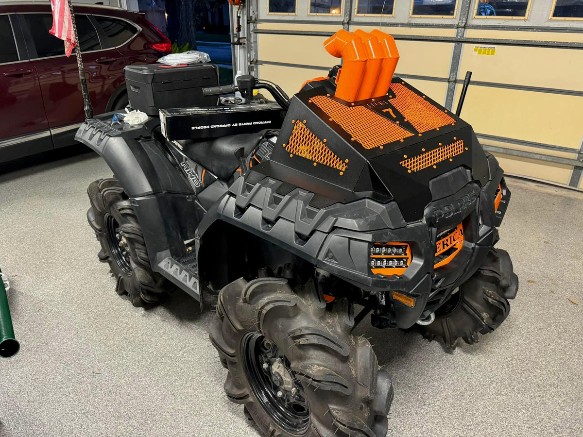 Orange Lucky 7 radiator cover and snorkel risers on a Polaris Sportsman High Lifter