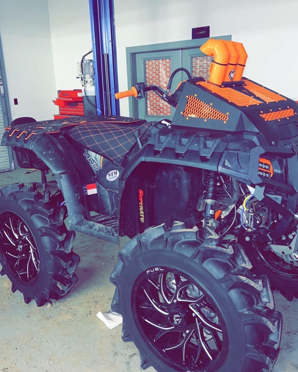Side view of an orange Lucky 7 radiator cover on a Polaris Sportsman High Lifter