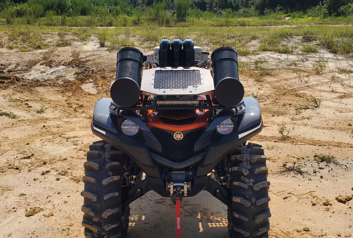 Lucky 7 Yamaha Grizzly Kodiak low profile mesh radiator relocation kit installed on a Grizzly in the mud