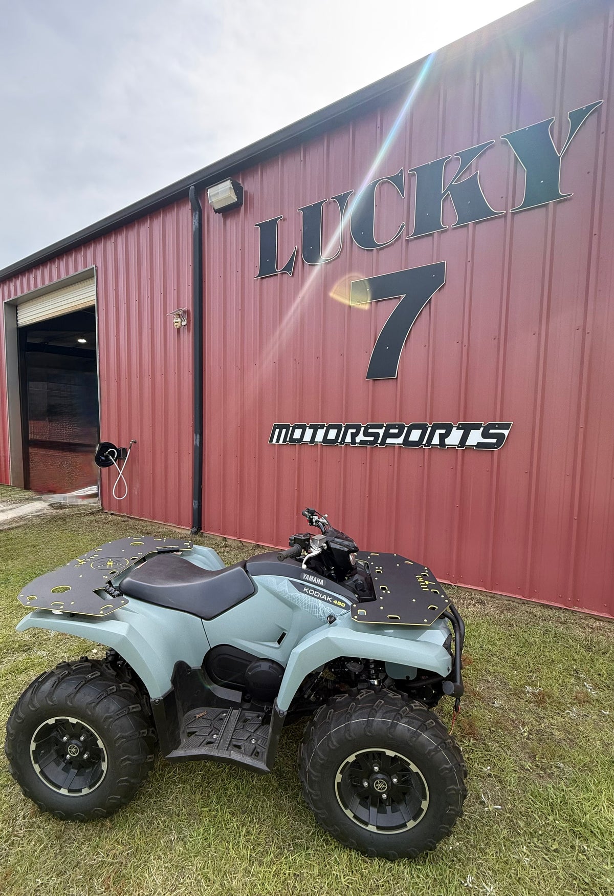 Yamaha Kodiak 450 with Lucky 7 Motorsports front and rear racks installed in front of the Milton, Florida shop
